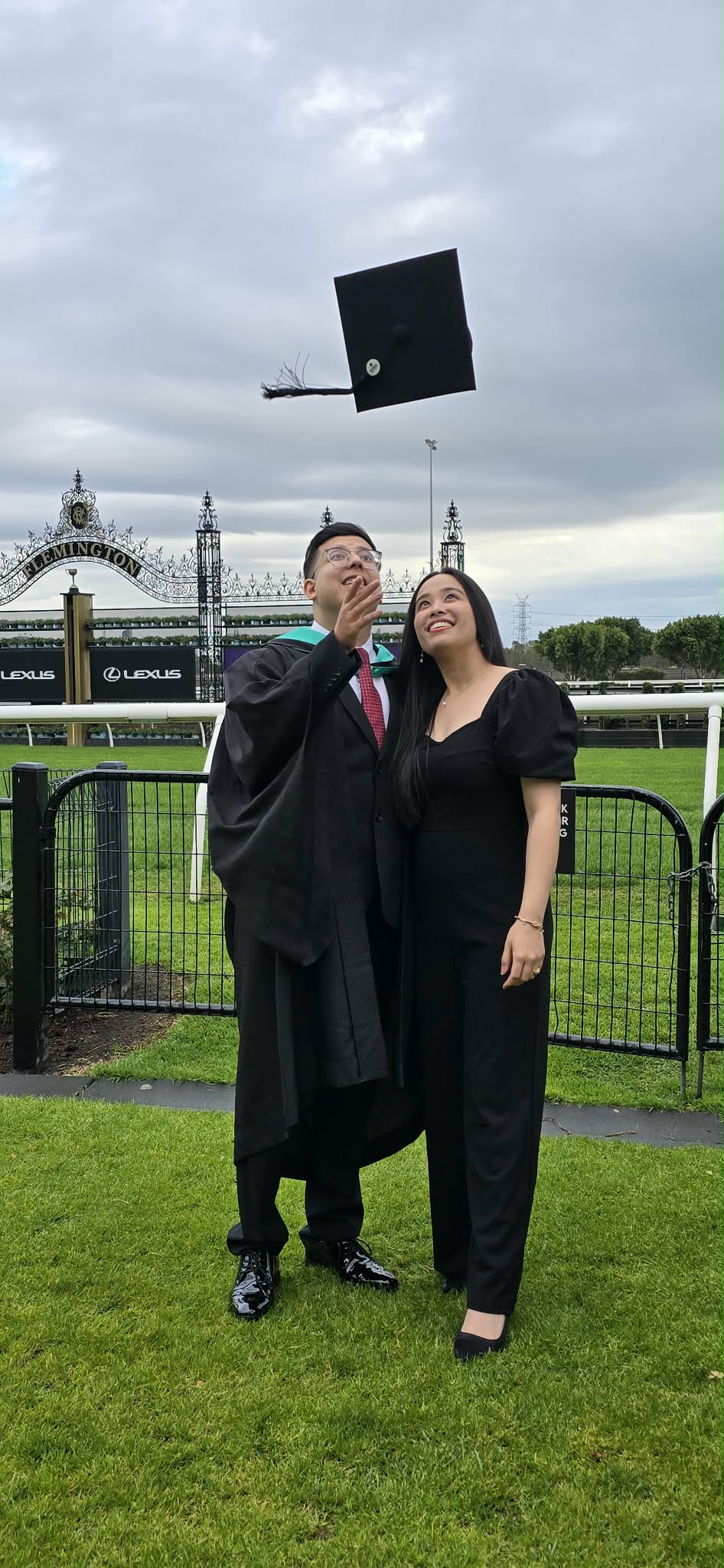 Abhishek and Alyssa celebrating graduation with a cap toss