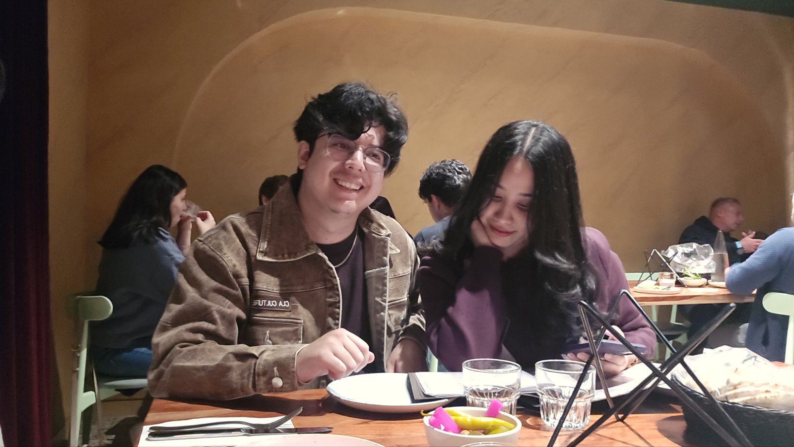 Abhishek and Alyssa sharing a restaurant meal